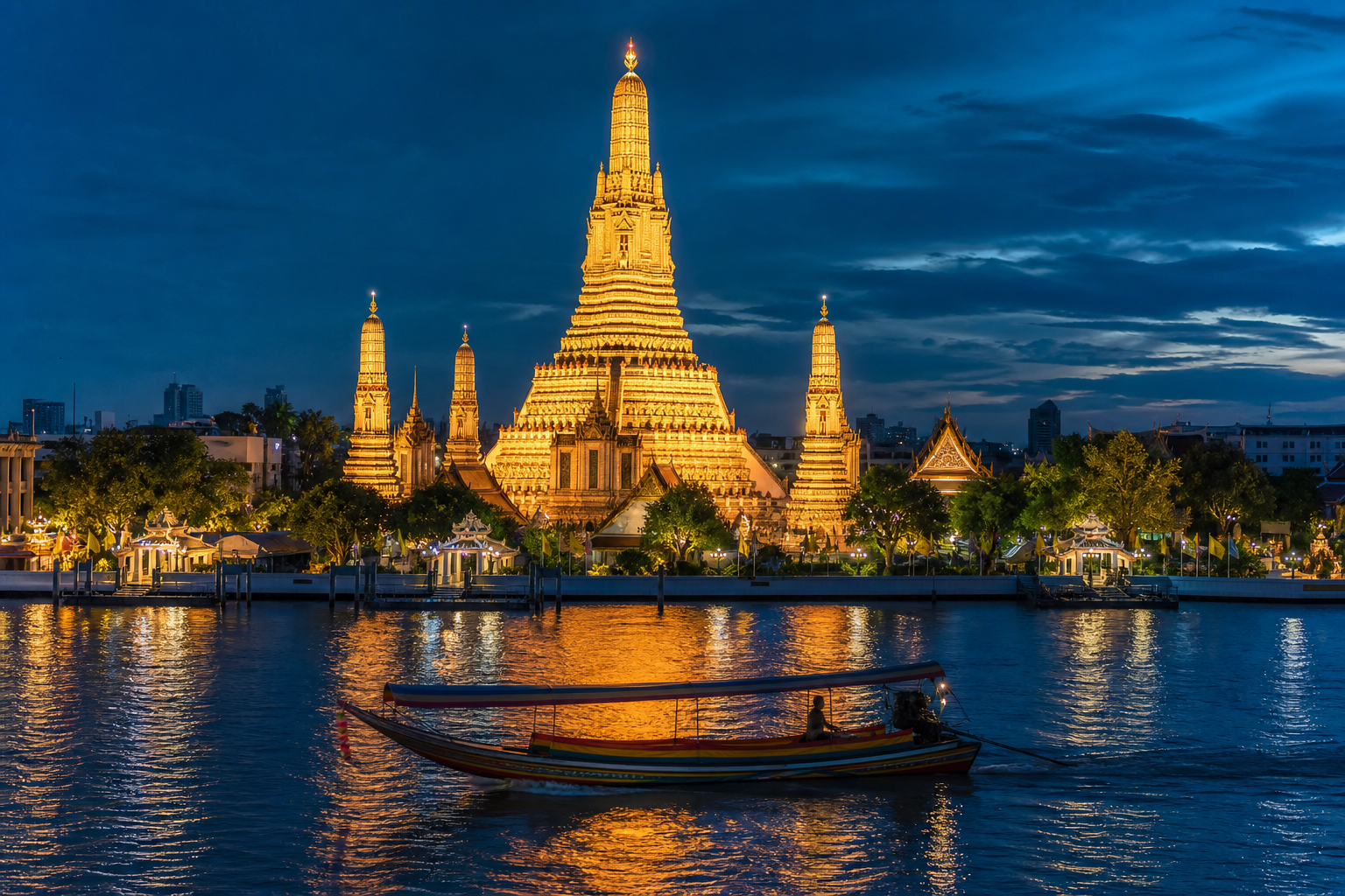Stunning nighttime view of Wat Arun lit up with golden lights reflected on the Chao Phraya River, with a traditional wooden boat passing in the foreground